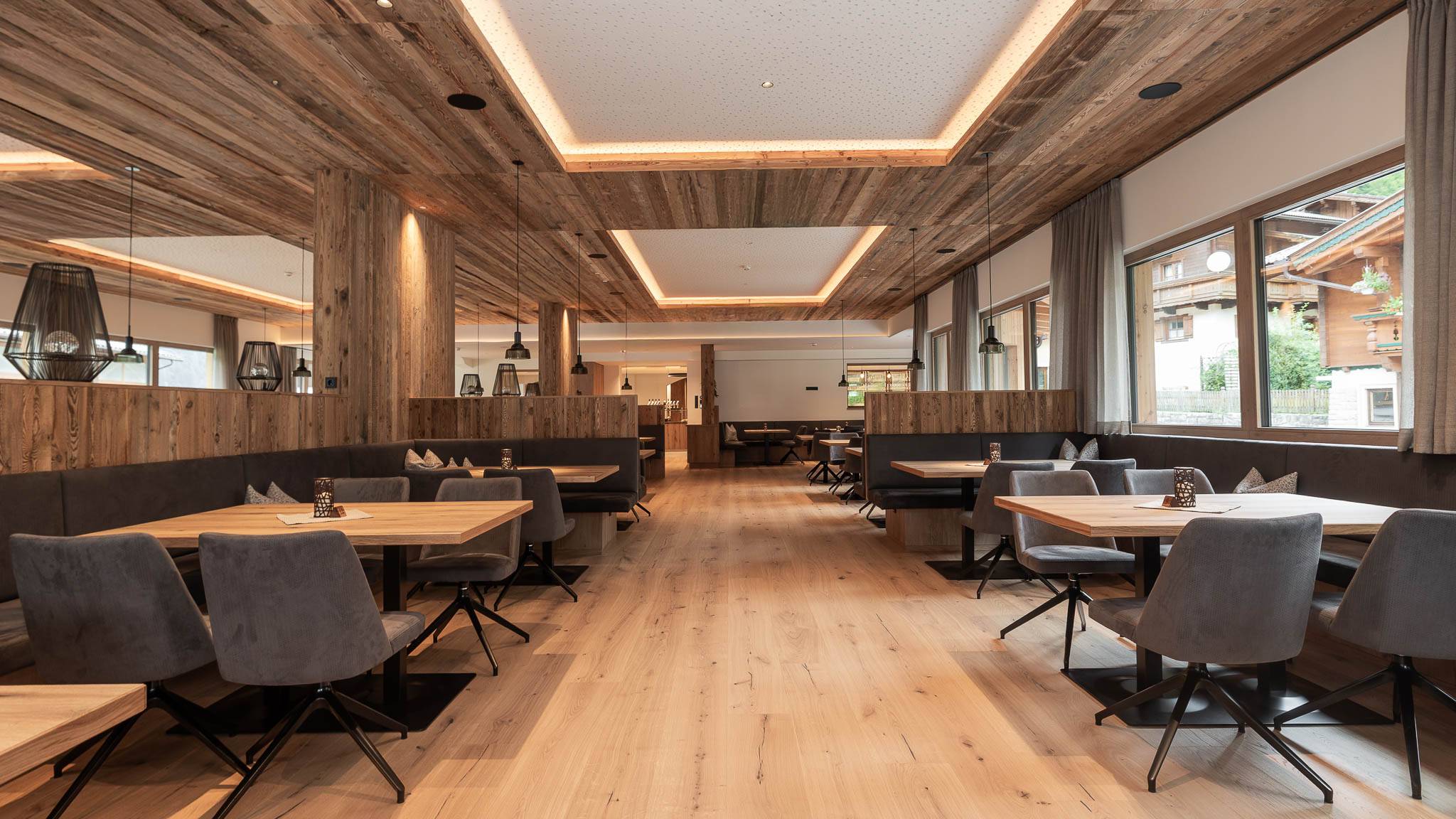 Gemütliche Sitzgelegenheiten im Restaurant des Hotel Oberkarteis mit modernen Polsterstühlen und warmem Holzdesign im Salzburger Land