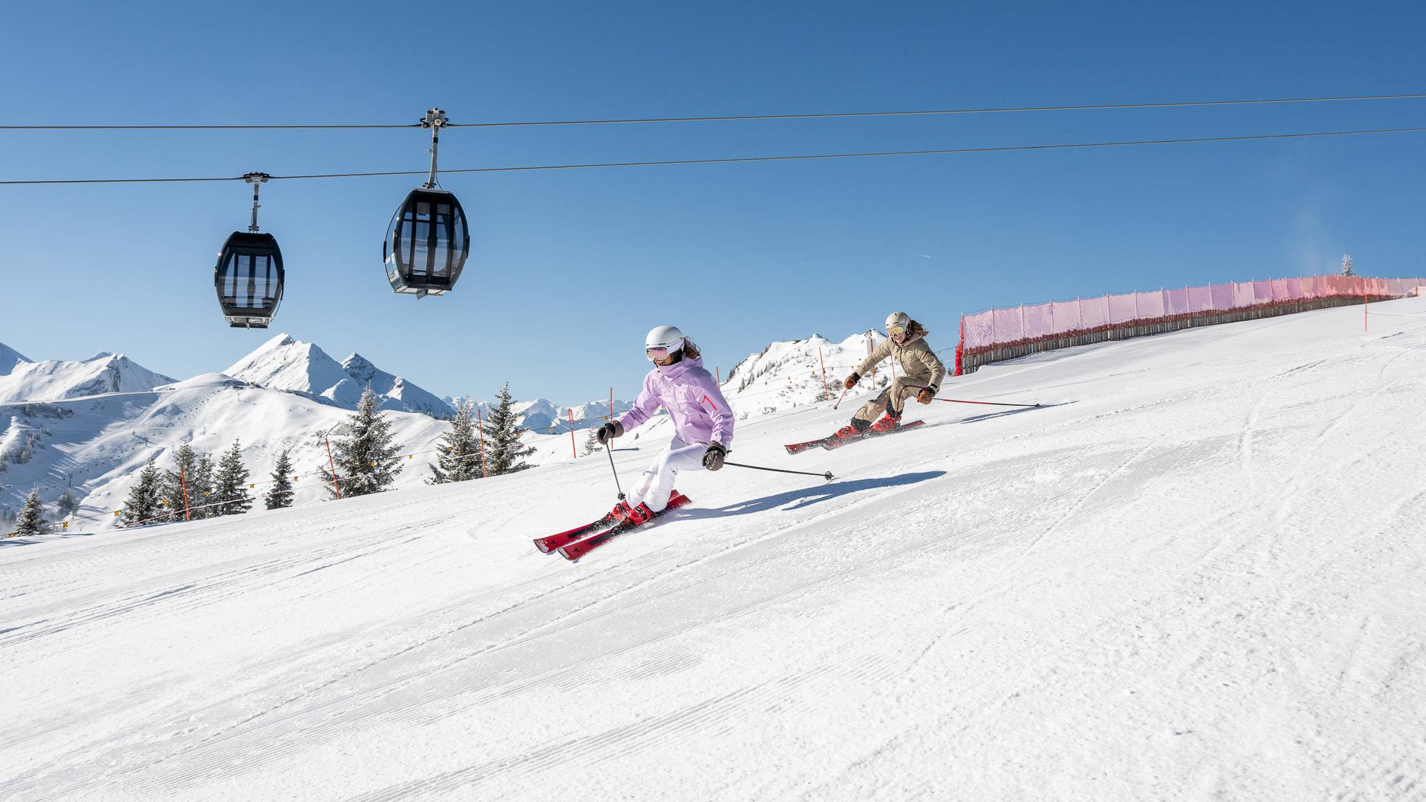 Skifahrerin bei der Abfahrt auf perfekt präparierter Piste im Skigebiet Großarl
