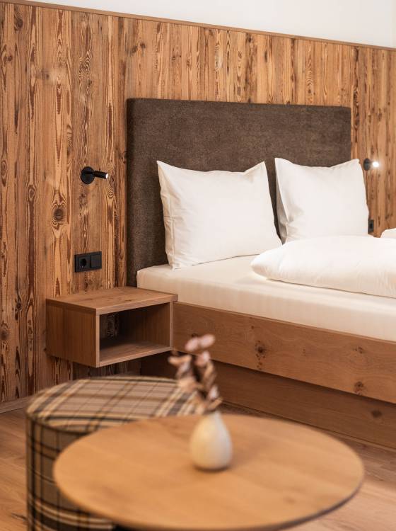 Wohnbereich mit Sofa, Tisch und Doppelbett im Hotelzimmer im Oberkarteis
