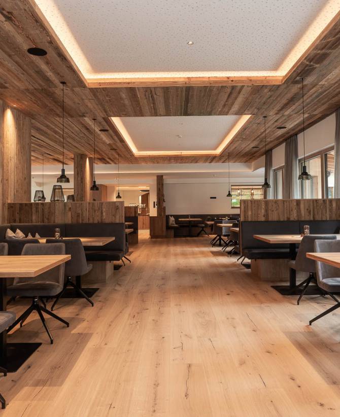 Gemütliche Sitzgelegenheiten im Restaurant des Hotel Oberkarteis mit modernen Polsterstühlen und warmem Holzdesign im Salzburger Land