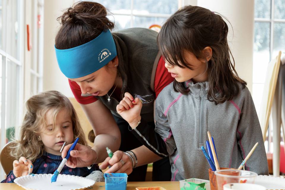 Kinder malen mit Betreuerin im Kreativraum der Kinderbetreuung im Familienhotel Oberkarteis