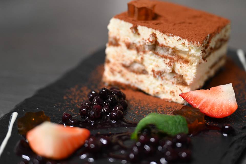 Hausgemachtes Tiramisu mit Beeren und Kakaopulver als Dessert im Hotel Oberkarteis