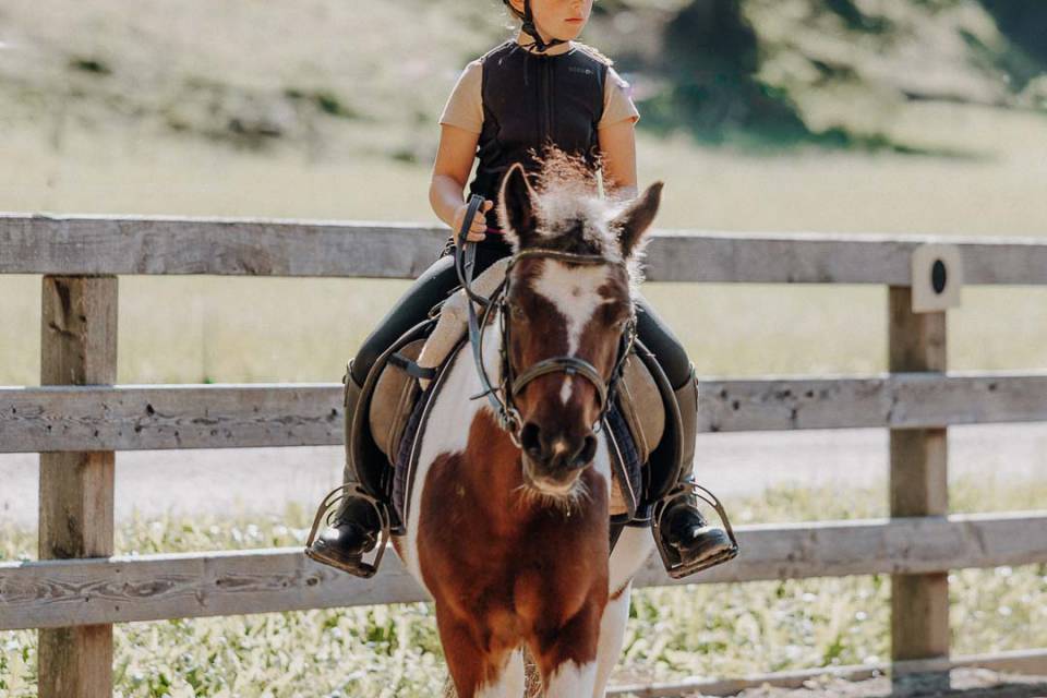 Mädchen reitet Pony auf dem überdachten Reitplatz im Reitstall Oberkarteis – professioneller Reitunterricht für Kinder