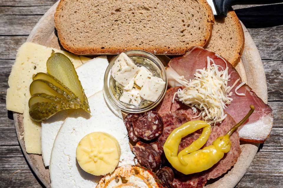 Traditionelle Brettljause mit Käse, Speck und Bauernbrot auf einer Alm im Salzburger Land im Sommer