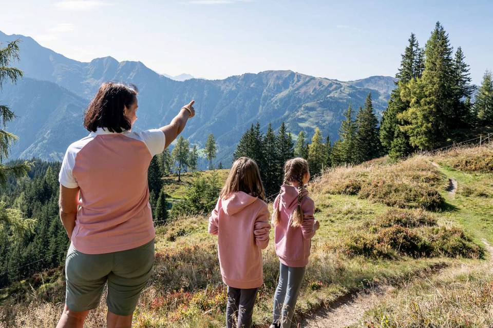 Mutter mit zwei Kindern auf einer Familienwanderung in den Bergen beim Familienhotel Oberkarteis