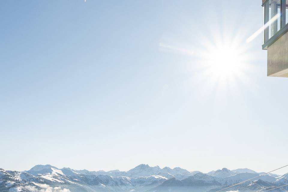 Skifahrer in strahlender Wintersonne vor beeindruckender alpiner Bergkulisse