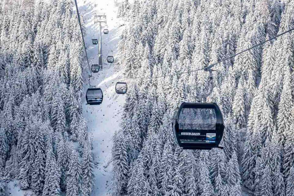 Moderne Gondelbahn über verschneitem Winterwald im Skigebiet Großarl