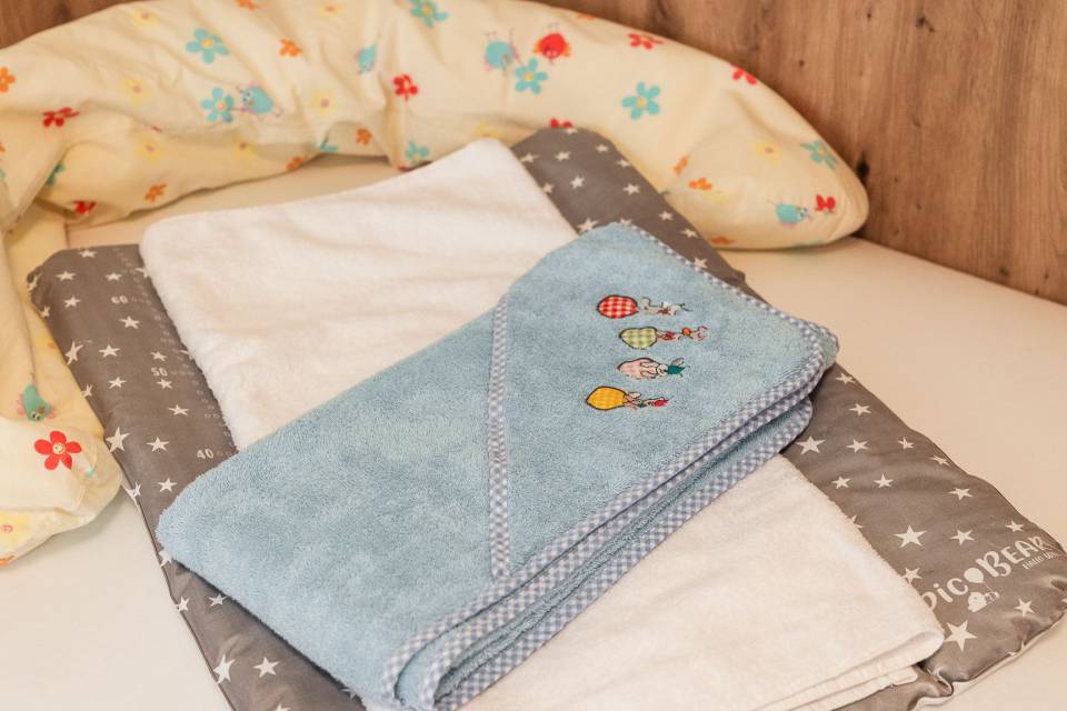 Babybett mit Decken und Wickelauflage im Familienzimmer Oberkarteis