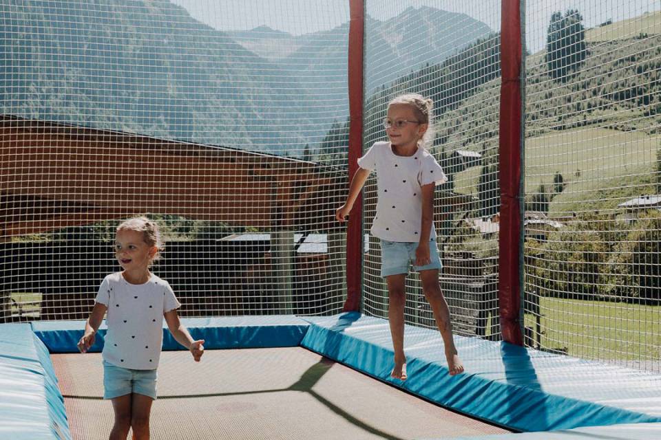 Zwei Mädchen auf dem Trampolin auf dem Abenteuerspielplatz des Hotels