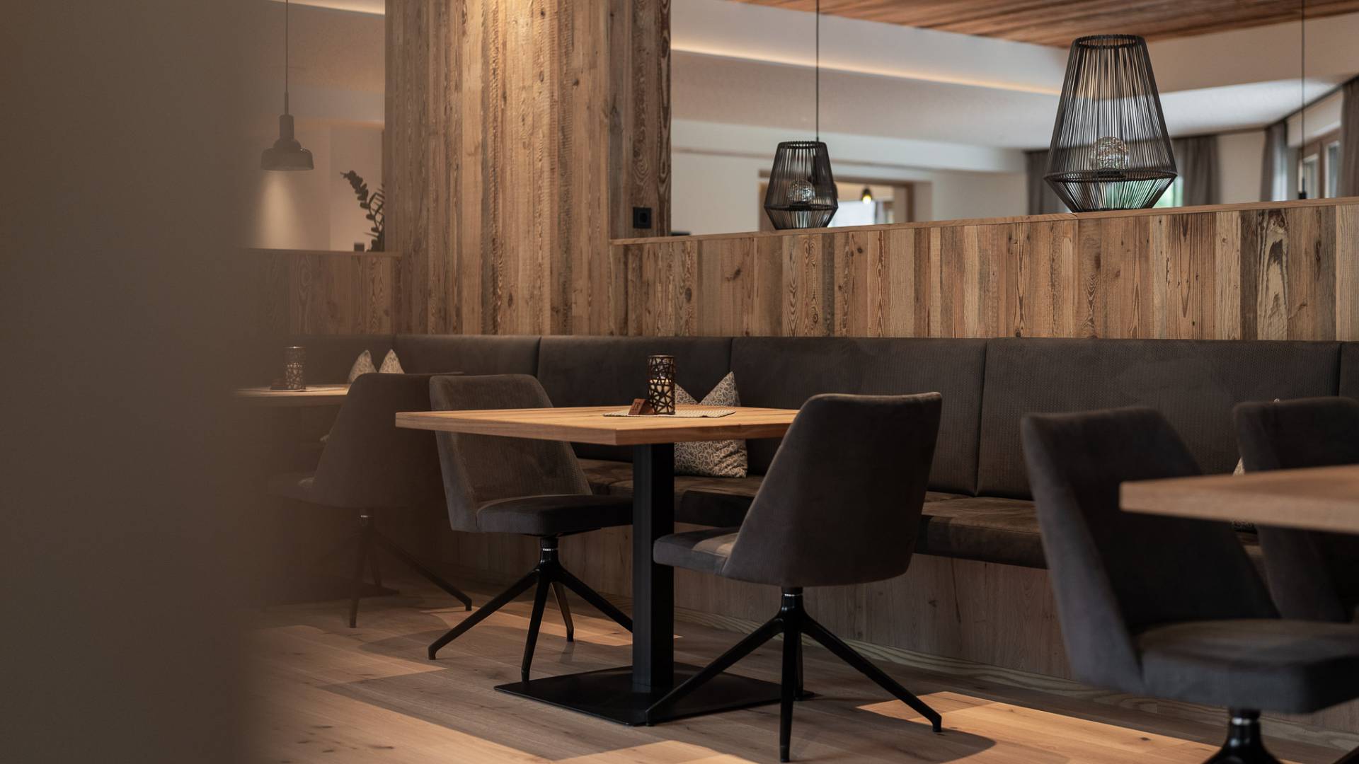 Detailaufnahme der gemütlichen Tische im Restaurant des Hotel Oberkarteis mit warmem Lichtkonzept