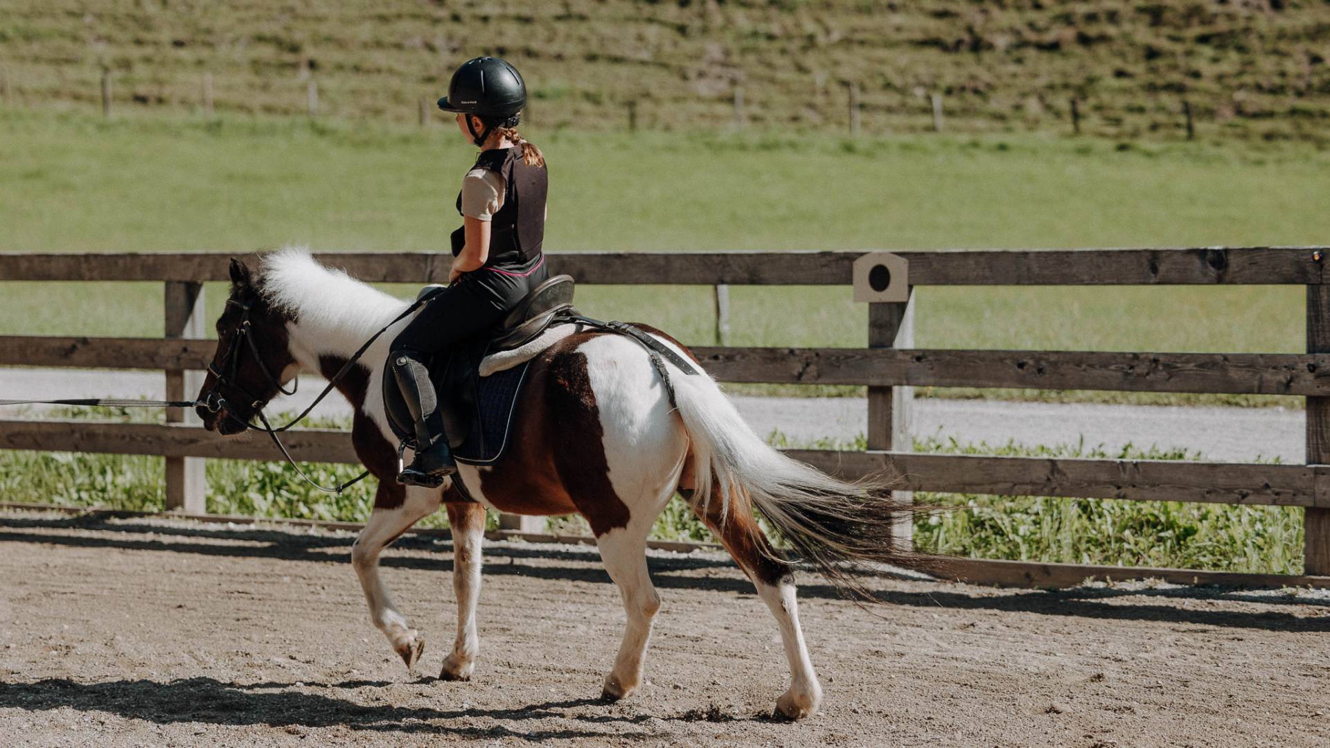 Kind im Trab auf Pony beim Reitunterricht für Kinder im Familienhotel Oberkarteis in Salzburg