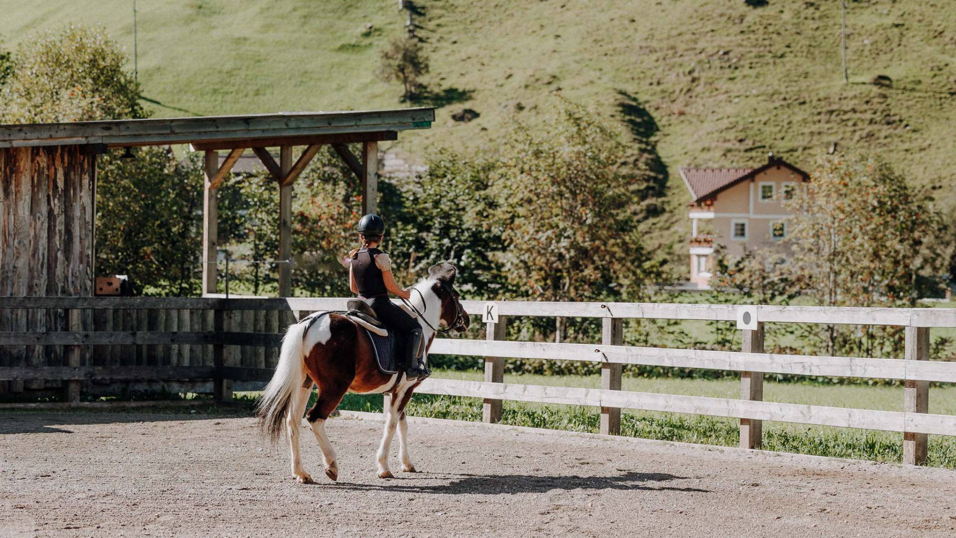 Reiterin mit Pony auf dem Reitplatz beim Reitunterricht im Familienhotel Oberkarteis in Salzburg