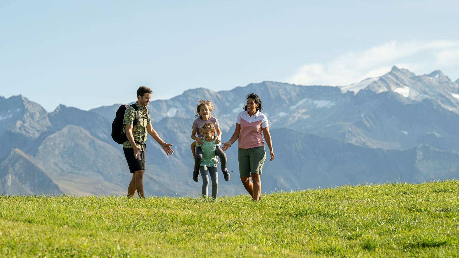 Eltern und Kinder bei Wanderung über grüne Almwiesen im Großarltal.