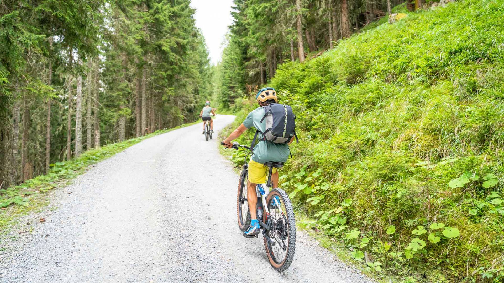Mountainbiker auf Forstweg durch Waldlandschaft nahe dem Familienhotel Oberkarteis im Salzburger Land