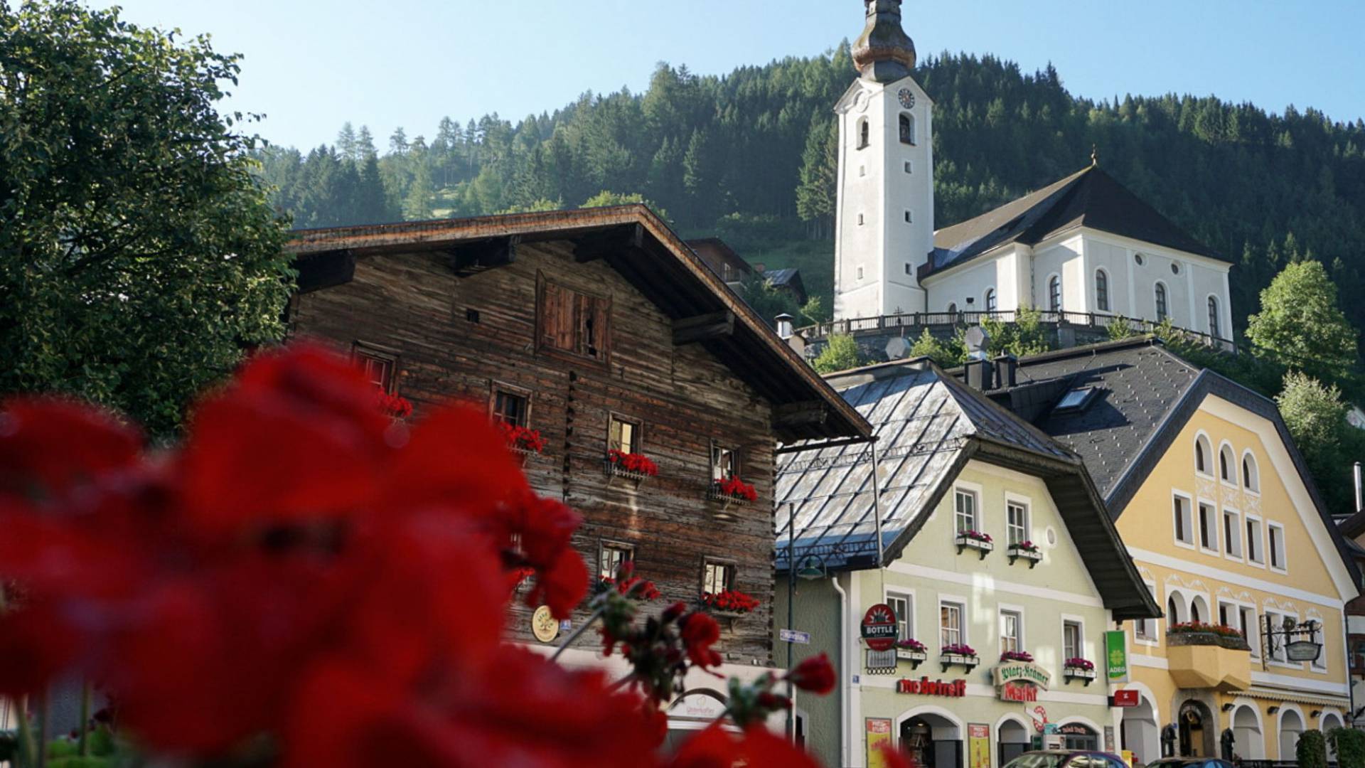 Historische Häuser und Kirche in einem idyllischen Ort im Salzburger Land nahe dem Familienhotel Oberkarteis