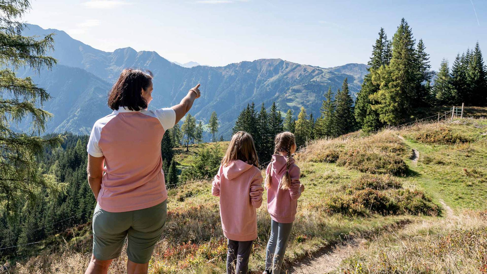 Mutter mit zwei Kindern auf einer Familienwanderung in den Bergen beim Familienhotel Oberkarteis