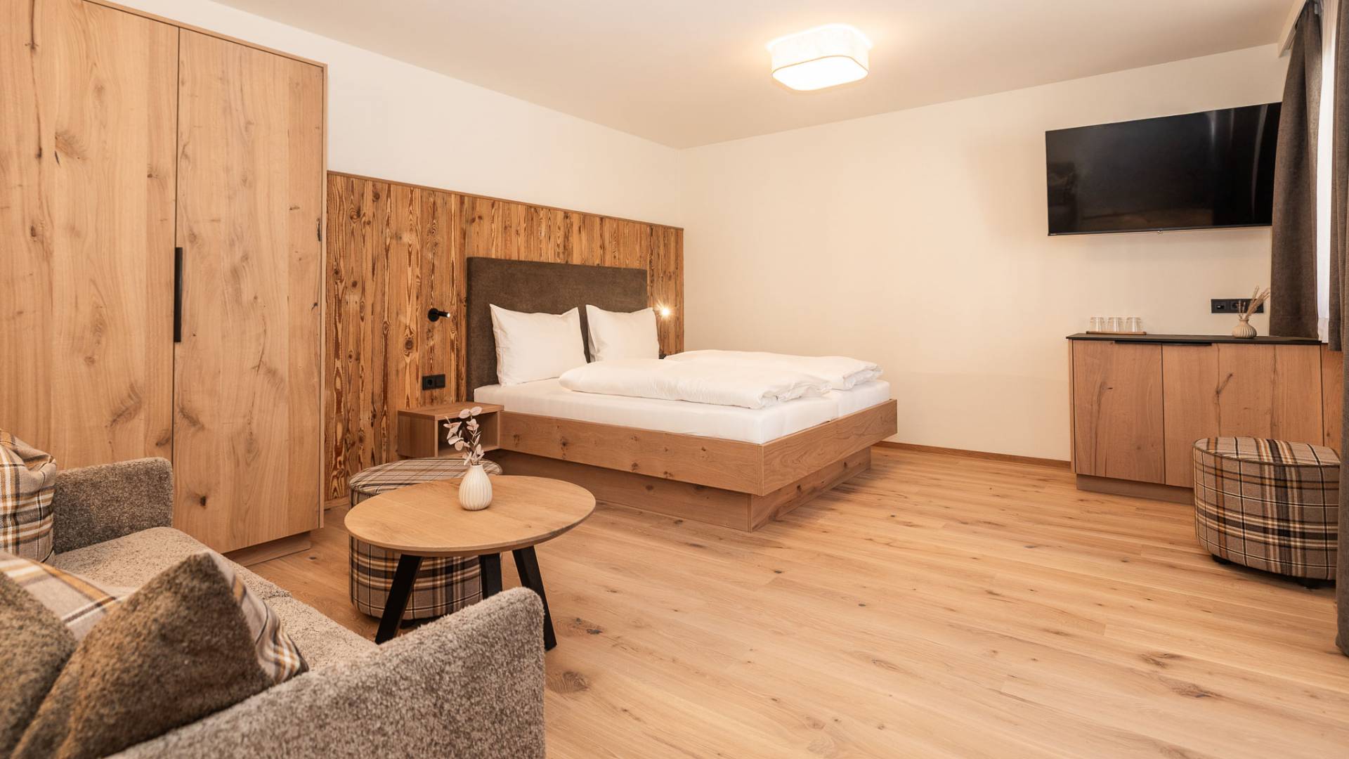 Wohn- und Schlafbereich mit Doppelbett, Couch und TV im Hotel Oberkarteis