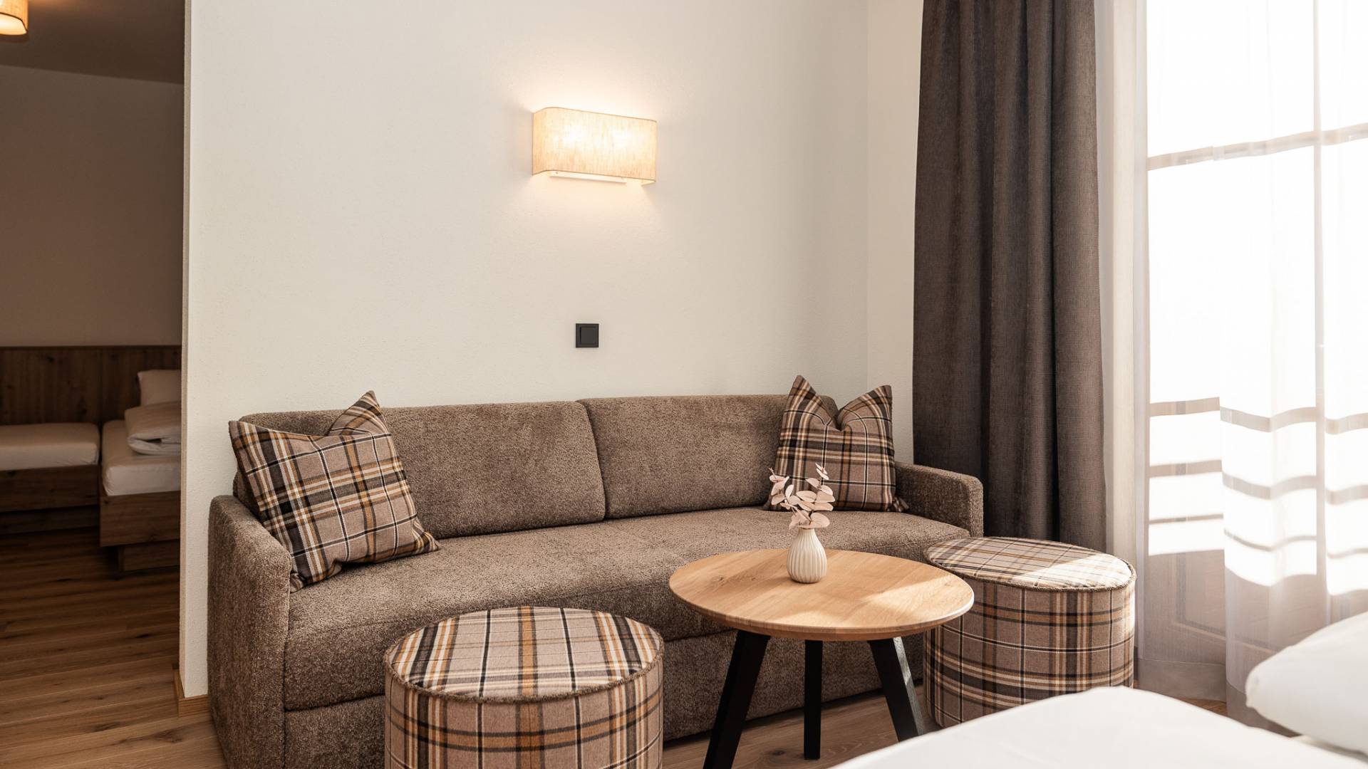 Bequemes Sofa mit Kissen im hellen Hotelzimmer des Familienhotels Oberkarteis