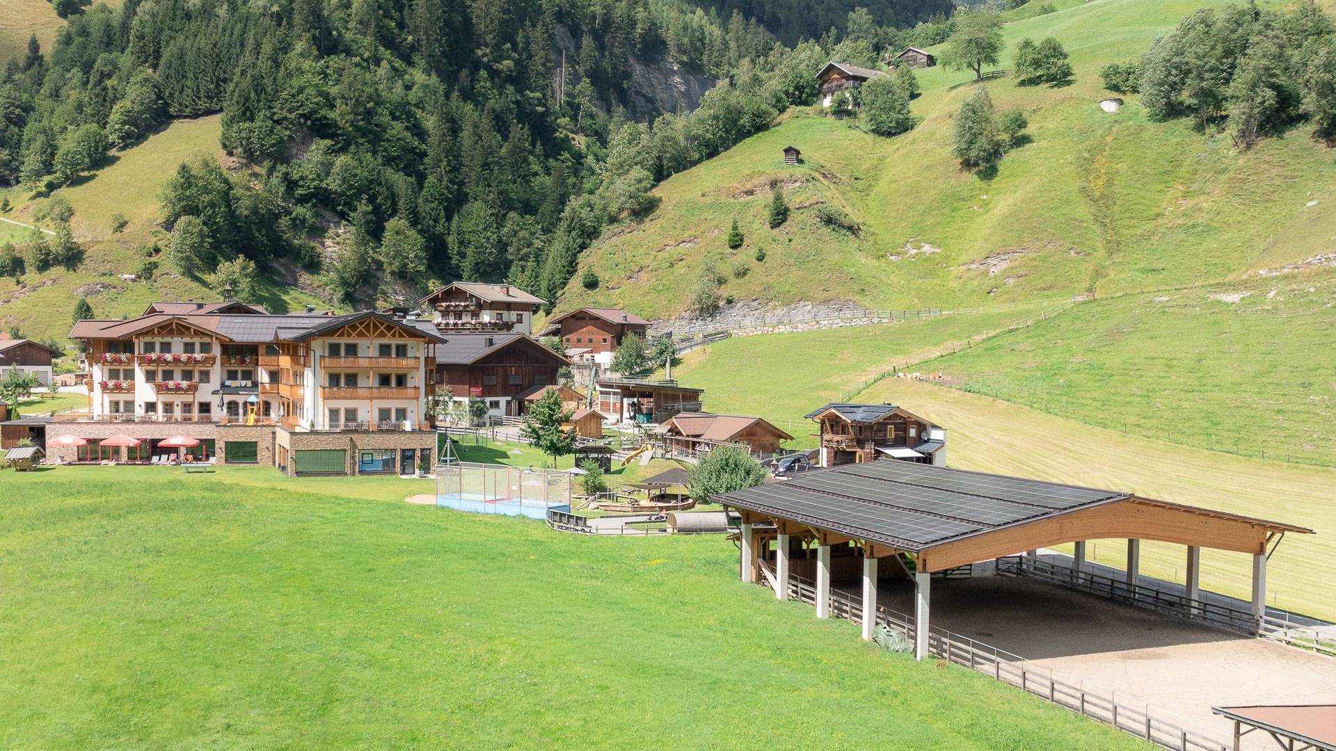 Familienhotel Oberkarteis mit Hof, Grünflächen und umliegender Berglandschaft