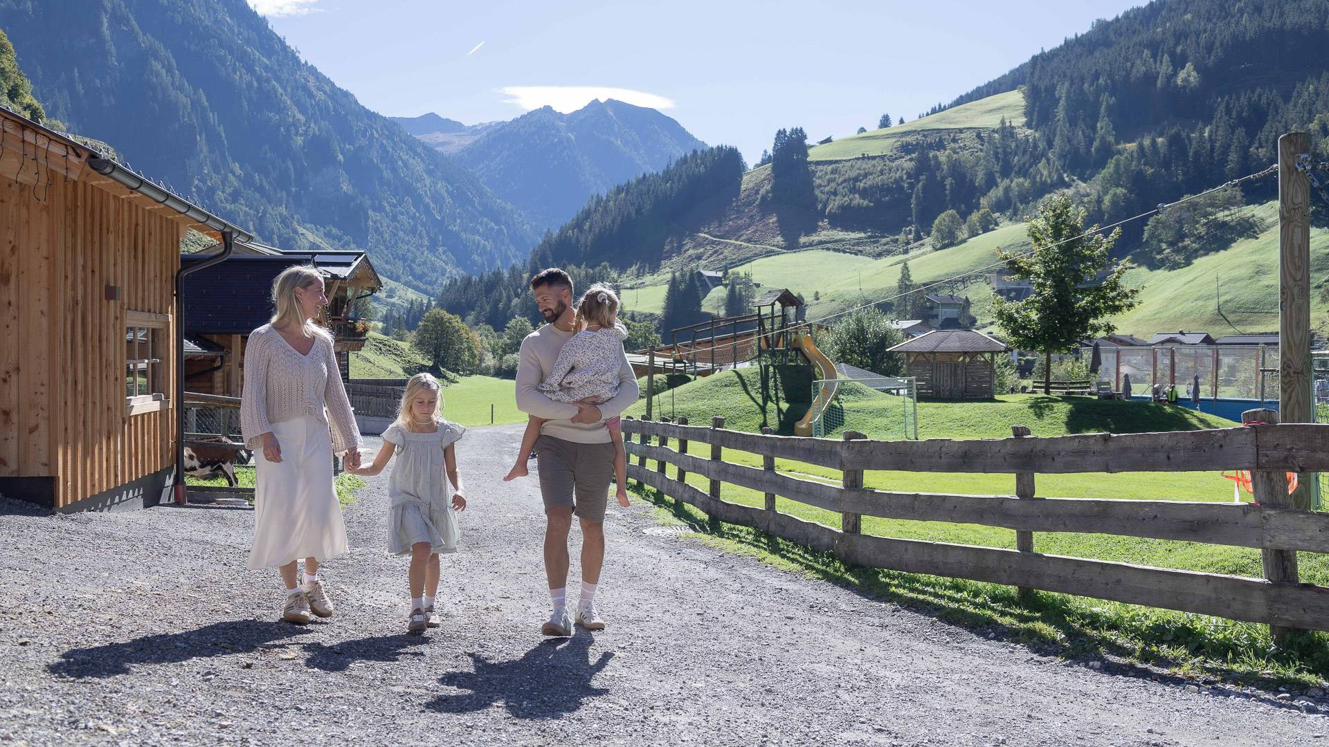 Familie im Außengelände des Familienhotels Oberkarteis, umgeben von Bergen.